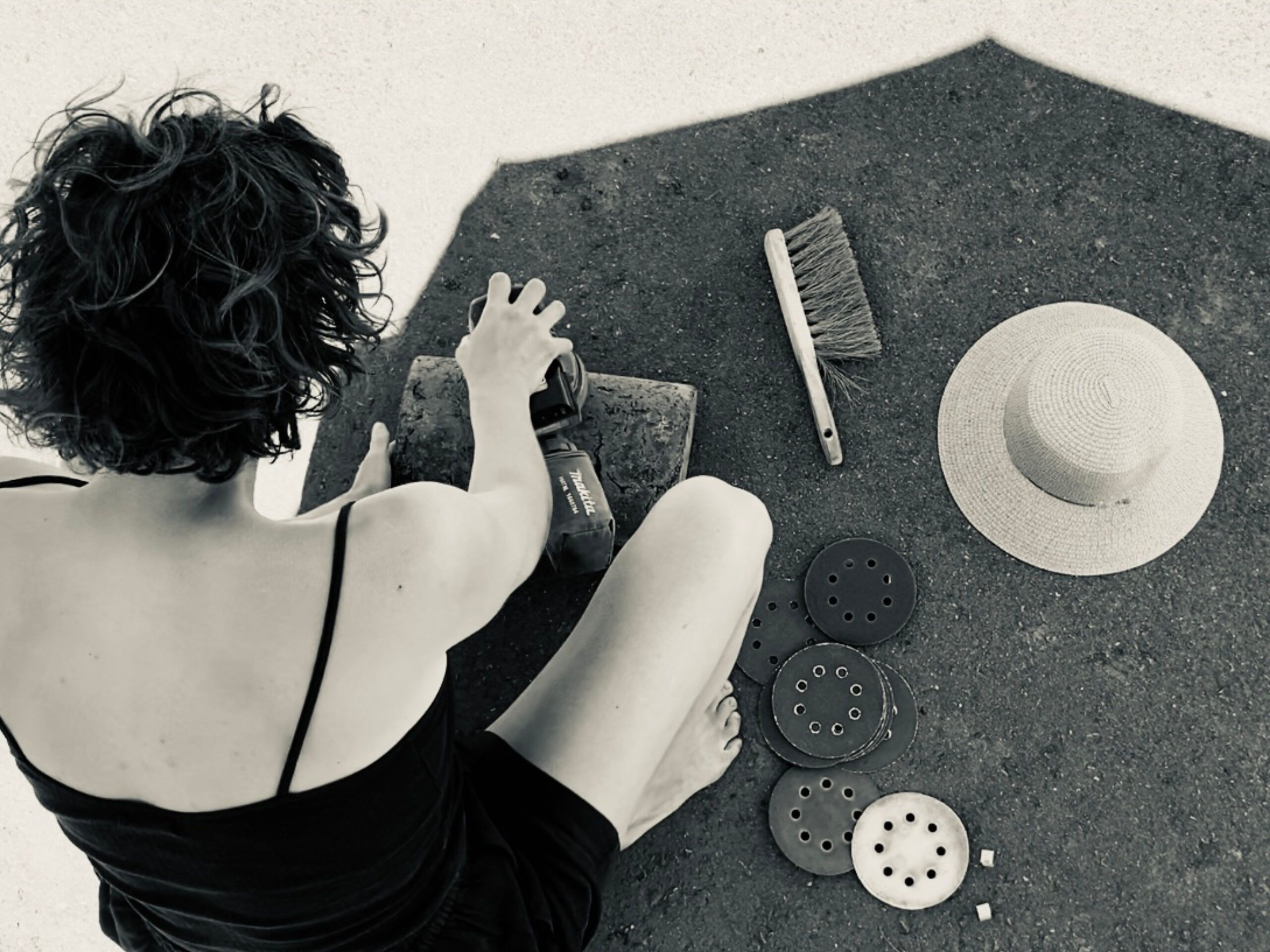 woman shaping a piece made from euca wood in the shadow, black and white picture